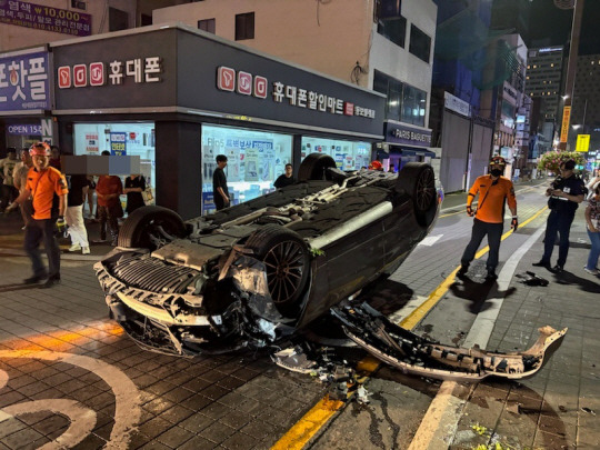 13일 오전 1시쯤 부산 해운대구청 어귀 삼거리에서 구청 방향을 달리던 벤츠 승용차가 가로등을 들이받고 뒤집혀 있다. 해운대경찰서 제공. 연합뉴스