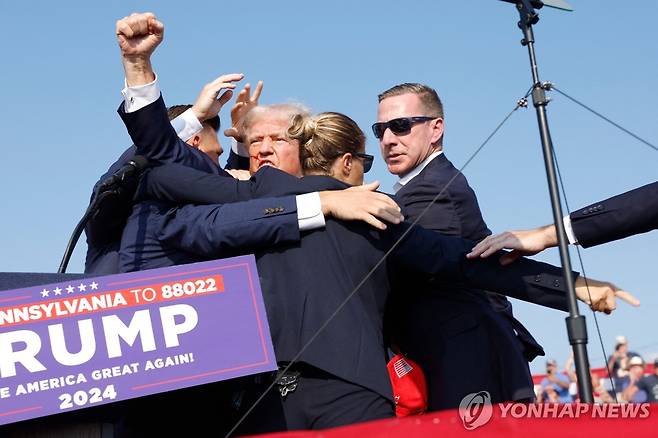 13일(현지시간) 미국 펜실베이니아 유세장서 총격 사건이 발생한 뒤 경호원들에 둘러 싸인 도널드 트럼프 전 대통령 [AFP 연합뉴스 자료사진]