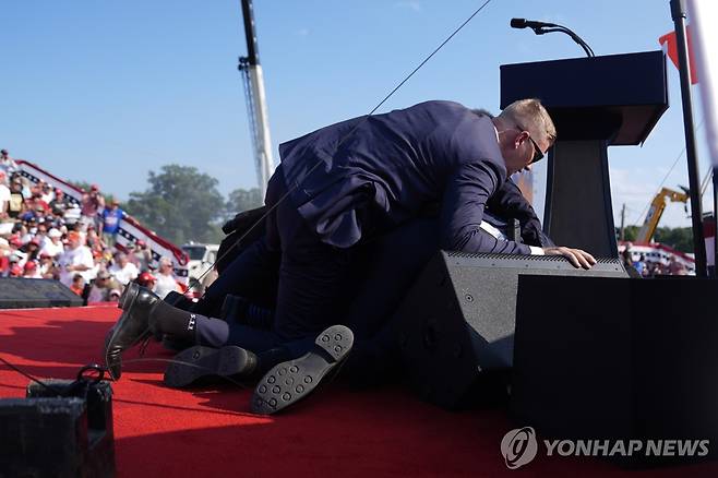 Election 2024 Trump Republican presidential candidate former President Donald Trump is covered by U.S. Secret Service agents at a campaign rally, Saturday, July 13, 2024, in Butler, Pa. (AP Photo/Evan Vucci)