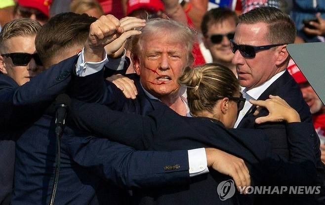 도널드 트럼프 전 미국 대통령 피격 (AFP=연합뉴스) 도널드 트럼프 전 미국 대통령이 13일(현지시간) 펜실베이니아주 버틀러에서 야외 유세를 하던 중 피격돼 피를 흘리고 있다. 2024.7.14 photo@yna.co.kr