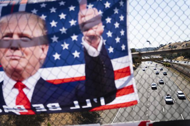미국 캘리포니아 라파예트의 24번 고속도로 고가도로에 공화당 대선 후보 도널드 트럼프가 등장하는 깃발이 걸려 있다. AP/연합뉴스