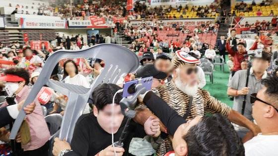 15일 천안 유관순체육관에서 열린 국민의힘 제4차 전당대회 대전·세종·충북·충남 합동연설회에서 참석자들 일부가 연설 중인 한동훈 후보에게 '배신자'라 외치며 의자를 집어 던지려고 하자 경호원과 당직자들이 제지하고 있다. 뉴시스