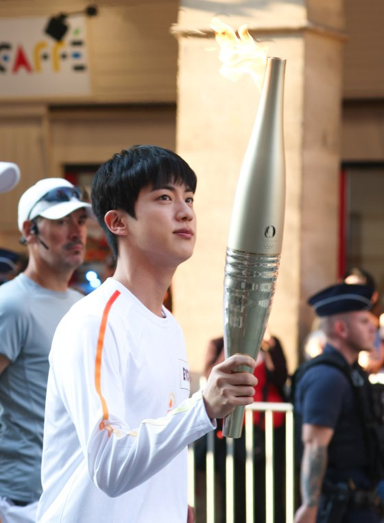 Jin carries the Olympic torch in Paris on July 14. [NEWS1]