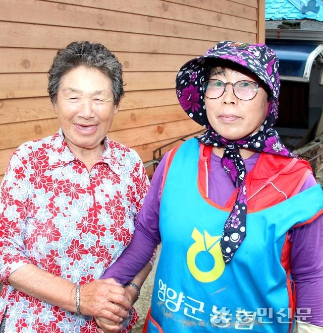 허미숙씨(오른쪽)와 김춘자 할머니가 손을 잡고 밝게 웃고 있다.