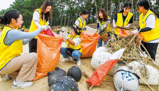 충남 보령시 원산도해수욕장에서 열린 ‘플라스틱발자국 지우기’ 캠페인에 참여한 봉사자들이 바다에서 떠밀려온 부표, 그물, 어망 등 각종 쓰레기를 수거하고 있다. [하나님의 교회 제공]