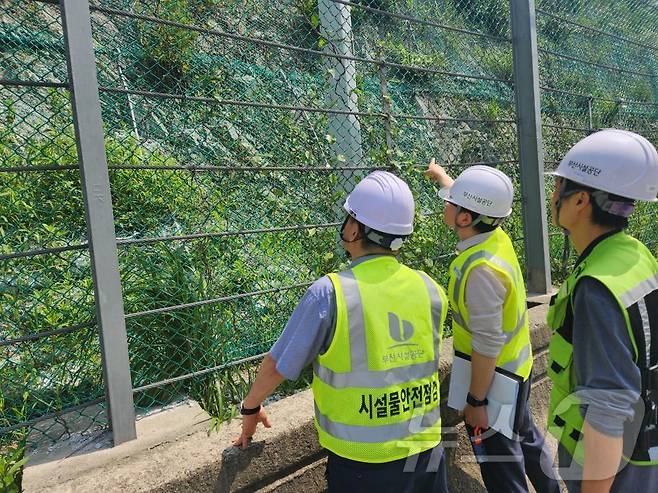 부산시설공단 합동점검반이 지상웅동연결도로 보강토옹벽을 둘러보며 안전점검을 하고 있다.(부산시설공단 제공)