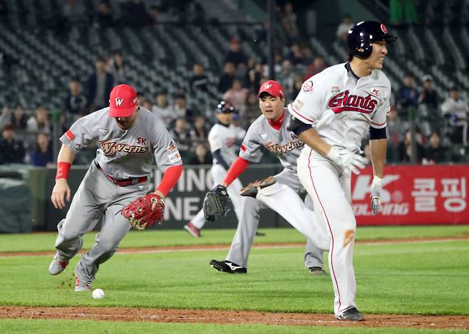 <yonhap photo-3830=""> 2019년 5월 3일 부산 사직야구장에서 열린 프로야구 SK 대 롯데경기. 6회말 무사 1.2루에서 롯데 강로한이 번트를 대고 1루로 달리는 사이 SK 1루수 로맥이 공을 잡고 있다. 강로한은 3피트 수비방해로 아웃됐다. 사진=연합뉴스</yonhap>