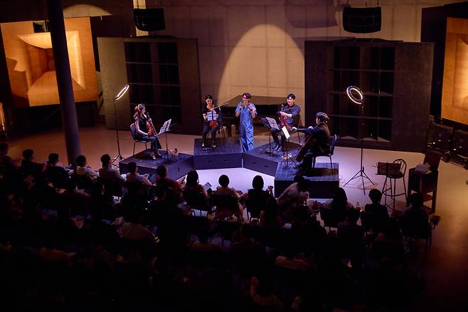 Lim Hee-yun, center, a music critic, speaks during a concert by the Korean National Symphony Orchestra quartet, consisting of violinists Kim Jeong, Kim A-hyun, violist Yoon Jee-hyun and cellist Choi Jung-woo, on Saturday at Concino Concrete in Paju. (KNSO)