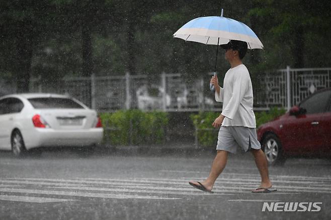 [광주=뉴시스] 이영주 기자 = 광주·전남에 장맛비가 내린 16일 오전 광주 서구 광주서부경찰서 앞 교차로에서 한 시민이 우산을 쓴 채 걸어가고 있다. 2024.07.16. leeyj2578@newsis.com