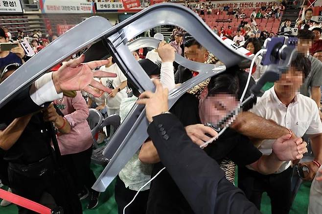 15일 오후 충남 천안시 유관순체육관에서 열린 국민의힘 제4차 전당대회 대전·세종·충북·충남 합동연설회에서 참석자들 일부가 연설중인 한동훈 후보에게 '배신자'라고 외치며 의자를 집어 던지려고 하자 경호원과 당직자들이 제지하고 있다.천안=뉴시스