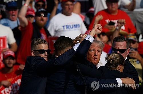 피흘리며 대피하는 트럼프  [버틀러 [미 펜실베이니아주] AFP=연합뉴스. 재판매 및 DB 금지]