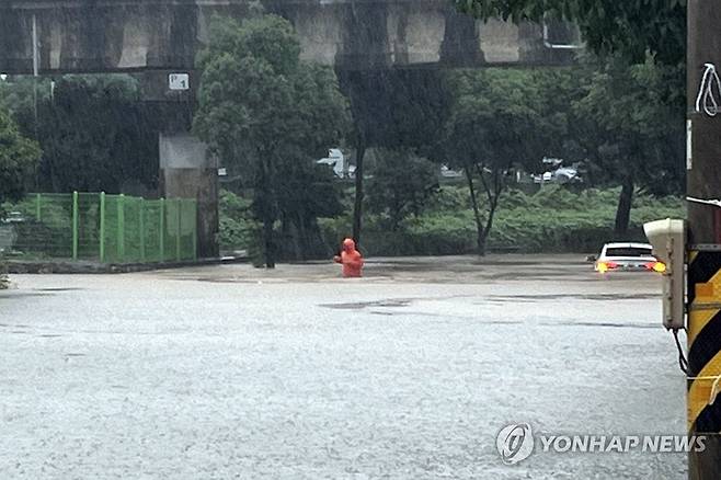 여수에 호우경보…침수된 하천 인접 도로 (여수=연합뉴스) 전남 동부권에 호우경보가 내려진 16일 오후 여수시 중흥동 중흥천 인근 도로가 침수돼 소방대원이 안전조치를 하고 있다. 2024.7.16 [여수소방서 제공. 재판매 및 DB 금지] hs@yna.co.kr