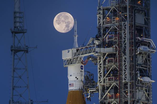 2022년 6월 14일 미 항공우주국(NASA) 케네디 우주센터의 아르테미스 대형 로켓 '스페이스론처시스템(SLS)'과 오리온 우주선 뒤로 보름달이 뜬 모습./NASA