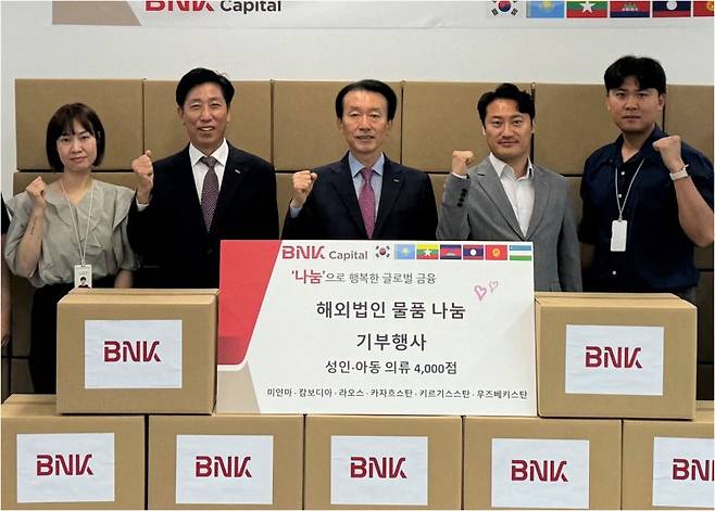 BNK캐피탈 김성주 대표이사(가운데)가 글로벌 물품 나눔 프로그램인 '2024 BNK해피쉐어링' 행사에 참석해 기념촬영을 하고 있다. BNK캐피탈 제공