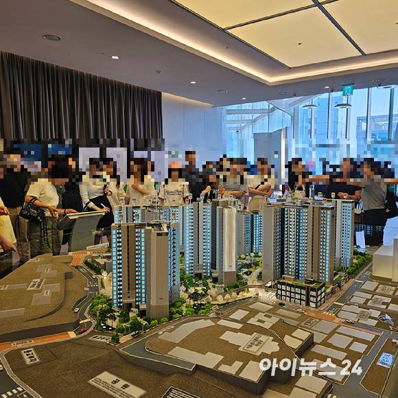 마포 자이힐스테이트 라첼스 견본주택 방문객들이 모형도를 구경하고 있다. [사진=이효정 기자 ]