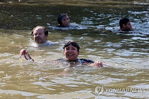 센강 뛰어든 이달고 파리 시장 (파리 AFP=연합뉴스) 안 이달고 프랑스 파리 시장이 17일(현지시간) 2024 파리올림픽을 앞두고 센강에서 수영하겠다는 약속을 지켰다. 2024.07.17.