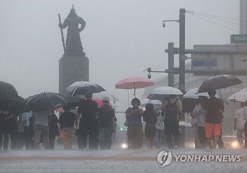 비가 내린 17일 오전 서울 종로구 광화문광장에서 시민들이 이동하고 있다. [연합뉴스]