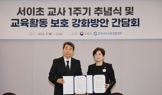 이주호 사회부총리 겸 교육부 장관과 전국시도교육감협의회장 강은희 대구교육감이 18일 오전 울산시 동구 타니베이호텔에서 열린 '서이초 교사 1주기 추념식 및 교육활동 보호 강화방안 간담회'에서 '교육활동 보호를 위한 공동선언문'을 들고 기념 촬영을 했다. 연합뉴스