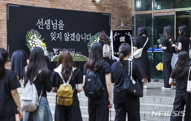 [서울=뉴시스] 정병혁 기자 = 서이초 순직교사 1주기인 18일 서울 서초구 서울교육대학교에서 열린 교사유가족협의회, 초등교사노동조합 2024 순직교사 추모행사를 찾은 교사 및 시민들이 헌화를 하기 위해 줄 서 있다.  2024.07.18. jhope@newsis.com