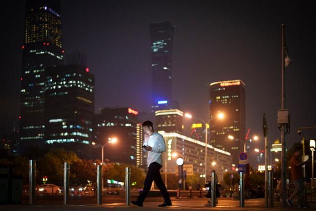 지난 15일 한 남성이 중국 베이징의 중앙업무지구를 지나고 있다. 베이징=AP 연합뉴스