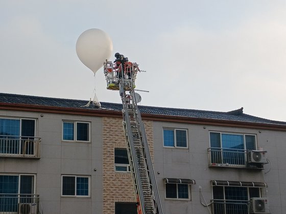 지난달 9일 인천 미추홀구 학익동 한 빌라 옥상에 떨어진 오물풍선을 소방대원이 치우고 있다. 뉴스1