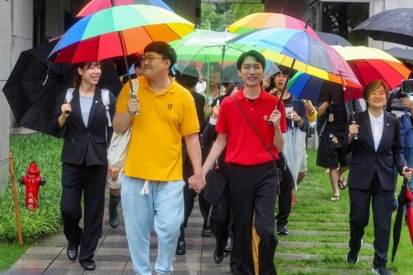 동성 연인 건강보험 피부양자 자격과 관련해 국민건강보험공단을 상대로 제기한 보험료 부과 처분 취소 소송에서 승소한 소성욱씨와 김용민씨(오른쪽)가 손을 잡고 밝은 표정으로 서울 서초구 대법원을 떠나고 있다.ⓒ연합뉴스