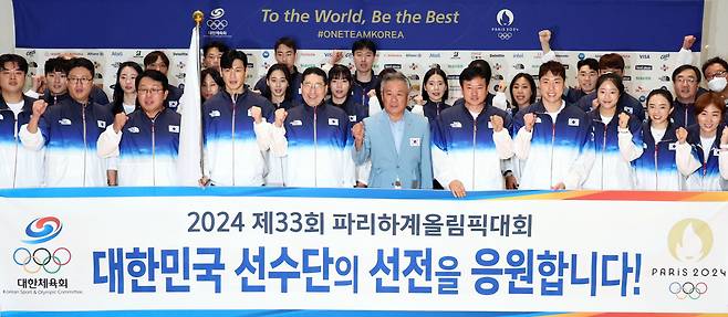 On Saturday, members of South Korea's main Olympic squad raise their fists in a show of solidarity at Incheon International Airport, west of Seoul, before their departure for France to compete in the Paris Olympics set to open next week. (Yonhap)