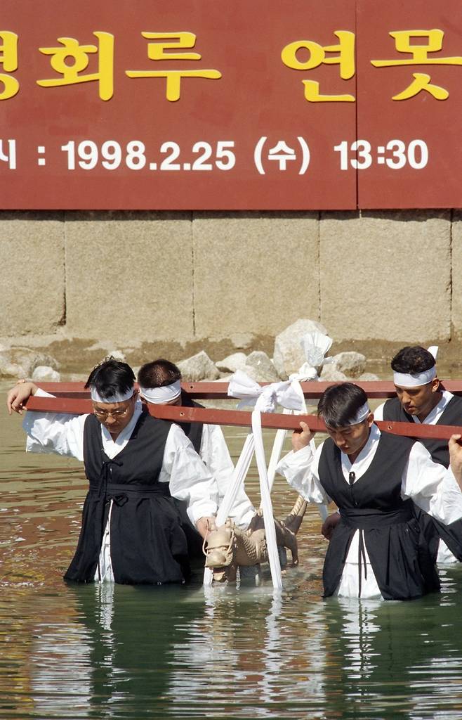 경회루 연못 준설공사 도중 발견된 청동용 복제품을 연못 새 물 담기 행사에서 본래 지점에 안치하고 있다. 1998년 [연합뉴스 자료사진]