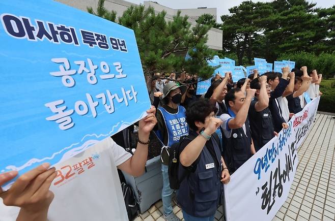 아사히글라스 하청업체 해고 근로자들이 7월 11일 서울 서초구 대법원에서 열린 근로자지위 확인 소송에서 승소 판결을 받은 뒤 기자회견을 열고 구호를 외치고 있다. 사진=연합뉴스