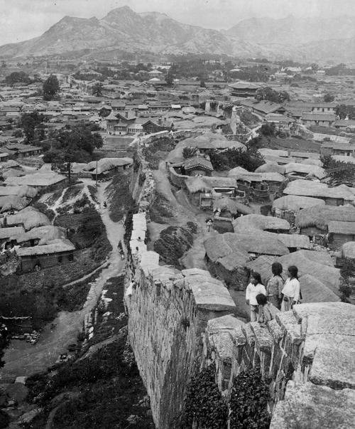 숭례문 안팎의 조밀한 민가(1905년). 서울은 조선 후기 전국에서 인구가 몰려들면서 땅값 상승, 주택난이 초래됐다. 어린이들이 서 있는 쪽이 남산방향이다.  호주 빅토리아국립도서관(조지 로스 촬영)