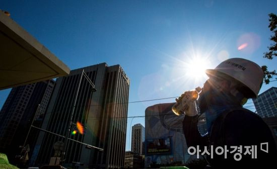 서울 한 낮 최고 기온이 40도 가까이 오를 것으로 예보된 1일 서울 중구 한 건설현장에서 근로자가 쉬는 시간을 이용해 목을 축이고 있다./강진형 기자aymsdream@