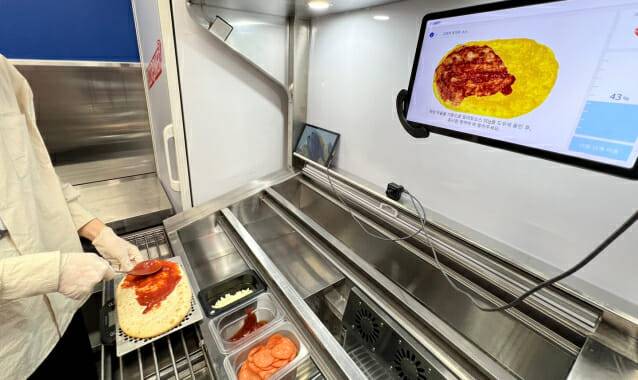 AI 스마트 토핑 테이블을 활용하는 모습. 상단 화면에 레시피가 표시되고 토핑을 충분히 도포하면 다음 과정으로 넘어간다. (사진=지디넷코리아 신영빈 기자)