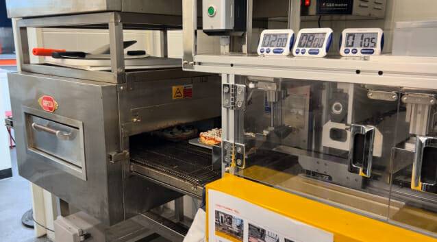 고피자를 기계에 투입하자 자동으로 커팅돼 차례로 컨베이어 오븐으로 이동했다. 토핑만 올려 넣으면 피자가 완성돼 나온다. (사진=지디넷코리아 신영빈 기자)