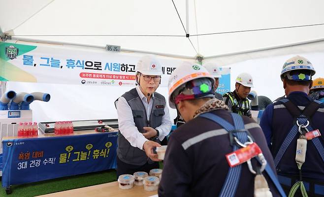 23일 충남 천안시 청당동에 위치한 '천안 롯데캐슬 더 청당 현장'에서 박현철 부회장(뒷줄 왼쪽 첫번째)이 근로자들에게 혹서기 용품을 나눠주고 있다. 롯데건설 제공