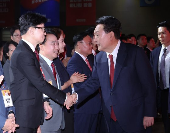 윤석열 대통령이 23일 경기 고양시 일산 킨텍스에서 열린 국민의힘 제4차 전당대회에 입장하며 한동훈 당대표 후보자와 인사하고 있다.뉴시스