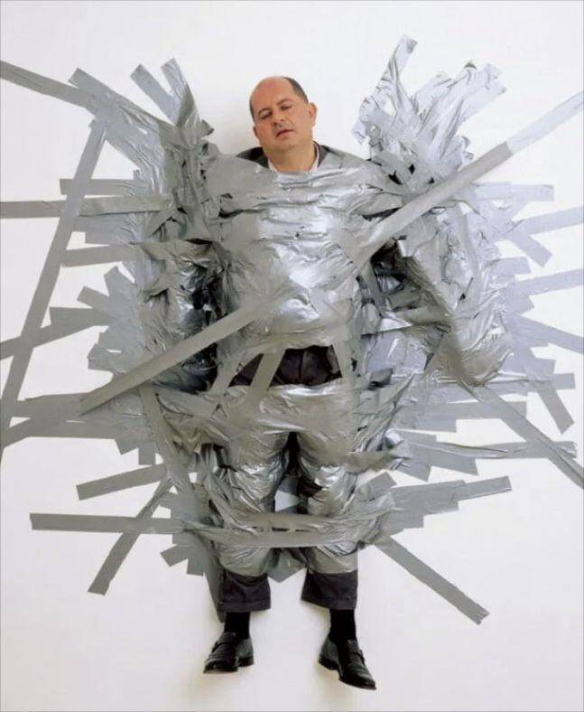 '미술계 악동' 마우리치오 카텔란이 1999년 선보인 퍼포먼스 작품 '완벽한 하루'. 3시간동안 전시장 벽에 테이프로 묶어둔 인물이 바로 자신의 화랑 대표인 마시모 데 카를로다. /마시모데카를로