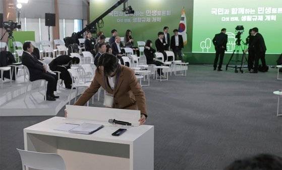 1월 22일 서울 동대문구 한국콘텐츠진흥원 콘텐츠인재캠퍼스에서 예정된 5차 ‘국민과 함께하는 민생토론회’에 윤석열 대통령의 불참이 결정되자 관계자가 윤 대통령 자리를 정리하고 있다. / 사진:대통령실사진기자단