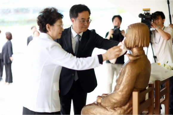 24일 오후 김동연 경기도지사가 부인 정우영 여사와 함께 소녀상을 닦아주고 있다. (경기도 제공)