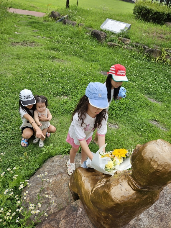 구례 네 자매가 소녀상에 꽃을 전달하고 있다. (경기도 제공)