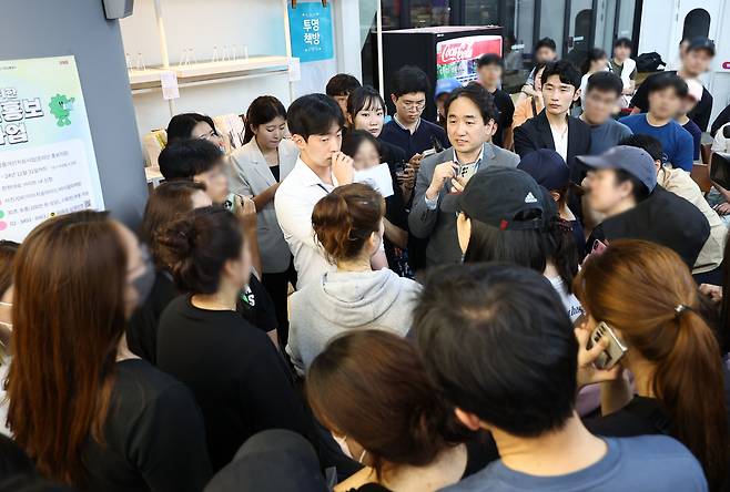 Ryu Hwa-hyun (center), co-chief executive of WeMakePrice, speaks to customers calling for refunds at the company's headquarters in Gangnam-gu, Seoul, Thursday. (Yonhap)