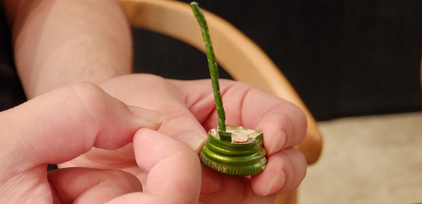 대표적인 술자리 게임인 ‘병뚜껑 게임’. 적당히 꼬아둔 소주 뚜껑의 꼬리 부분을 돌아가며 손가락으로 쳐서 먼저 떨어지게 만드는 사람이 걸리게 된다. [사진 출처=롯데주류]