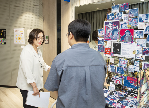 박희영(왼쪽) 서울 용산구청장이 지난 19일 ‘니트컴퍼니’ 활동 공유회에 참석해 참여자로부터 ‘니트투게더’ 전시회 설명을 듣고 있다. 용산구 제공