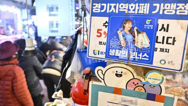 수원특례시 팔달구 한 시장에 부착돼 있는 경기지역화폐 홍보 및 사용 스티커 모습. 경기일보DB