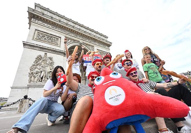 힘내라 대한민국 파리올림픽 개막을 하루 앞두고 주프랑스 한국문화원 직원과 프랑스 문화를 상징하는 마리니에르를 입은 파리 시민들이 파리 개선문 앞에서 한국 팀의 선전을 기원하고 있다.  파리 이충우 기자