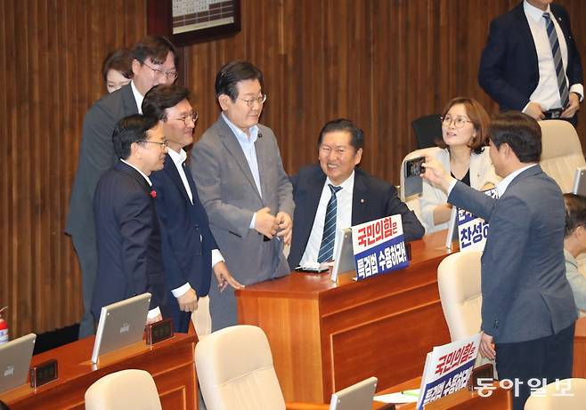 26일 오후 국회 본회의장에서 더불어민주당 의원들이 이재명 당 대표 후보를 둘러싼 채 밝게 웃으며 기념사진을 찍고 있다. 이날 
본회의에서 방송통신위원회 설치·운영법 개정안은 민주당 등 야당 의원 주도로 통과됐다. 국민의힘 의원들은 야당의 법안 강행 처리에 
항의하며 본회의장에서 퇴장해 표결에 불참했다. 이훈구 기자 ufo@donga.com