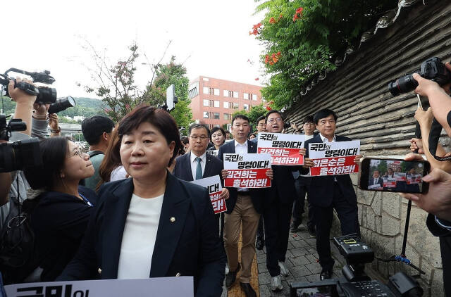 더불어민주당 김승원 법사위 간사 등 야당 법사위원들이 26일 오후 서울 용산구 한남동 대통령관저 인근에서 김건희 여사 청문회 불출석 규탄 및 출석 촉구 기자회견을 하기 위해 손팻말을 들고 이동하고 있다. 연합뉴스