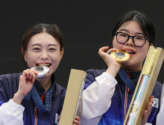 28일(현지시간) 프랑스 샤토루 슈팅 센터에서 열린 2024 파리올림픽 사격 공기권총 10m 여자 결선에서 금메달을 수확한 오예진(오른쪽)과 은메달을 딴 김예지가 메달을 입에 물고 기뻐하고 있다. 연합뉴스