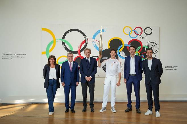 지난 15일(현지시간) 베르나르 아르노(왼쪽 세번째) LVMH 회장이 파리 루이비통 재단에서 열린 올림픽 성화 봉송 행사에 참여하고 있다. [AFP]