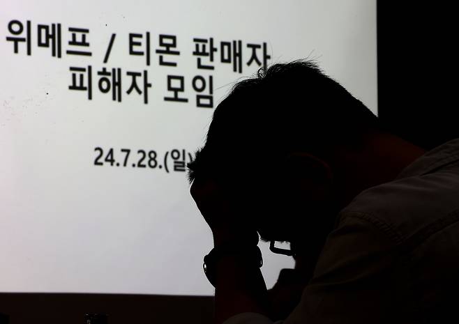 티몬·위메프 판매대금 정산 지연 사태가 이어지는 가운데 28일 오후 서울 강남구 역삼동의 한 빌딩에서 열린 티몬.위메프 피해 입점 판매자(셀러) 대책회의에 참석한 한 판매자가 머리를 쥐고 있다. 연합뉴스