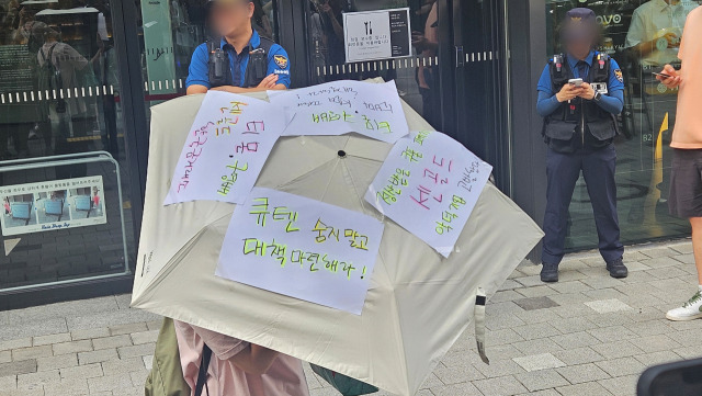 티몬·위메프 환불 지연 피해자가 28일 서울 강남구 큐텐 본사 건물 앞에서 우산을 들고 나와 항의 퍼포먼스를 선보이고 있다. 채민석 기자